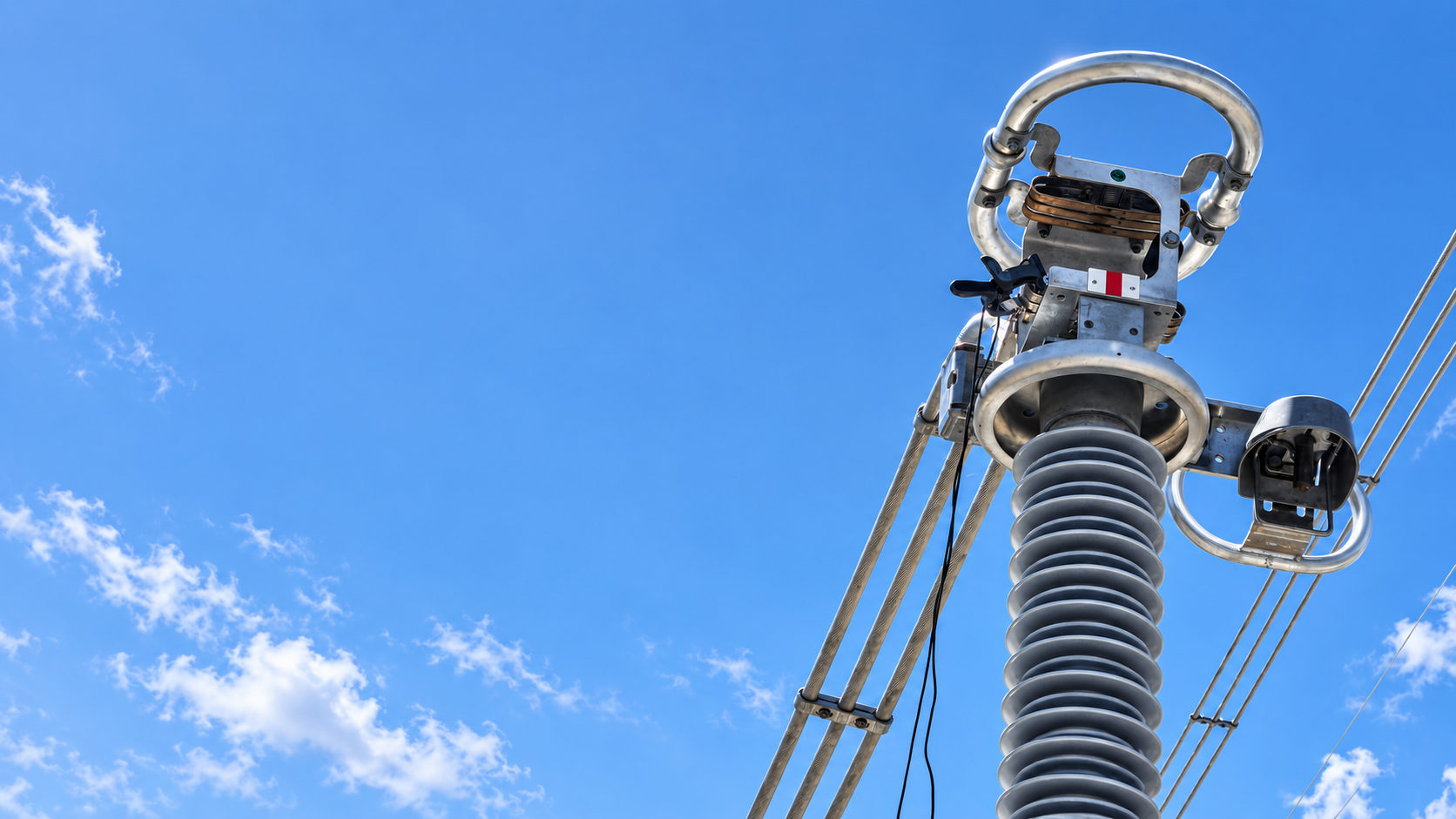 High-voltage disconnector at a transmission substation against a clear sky